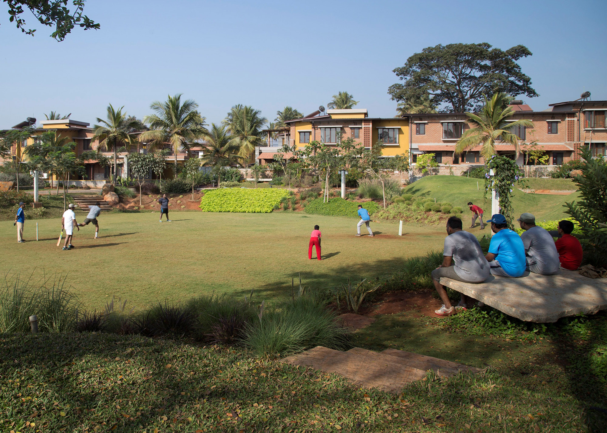 Community park being used to play cricket on a Sunday morning