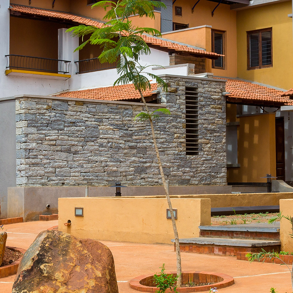 Stacked stone wall for courtyard at Good Earth Malhar