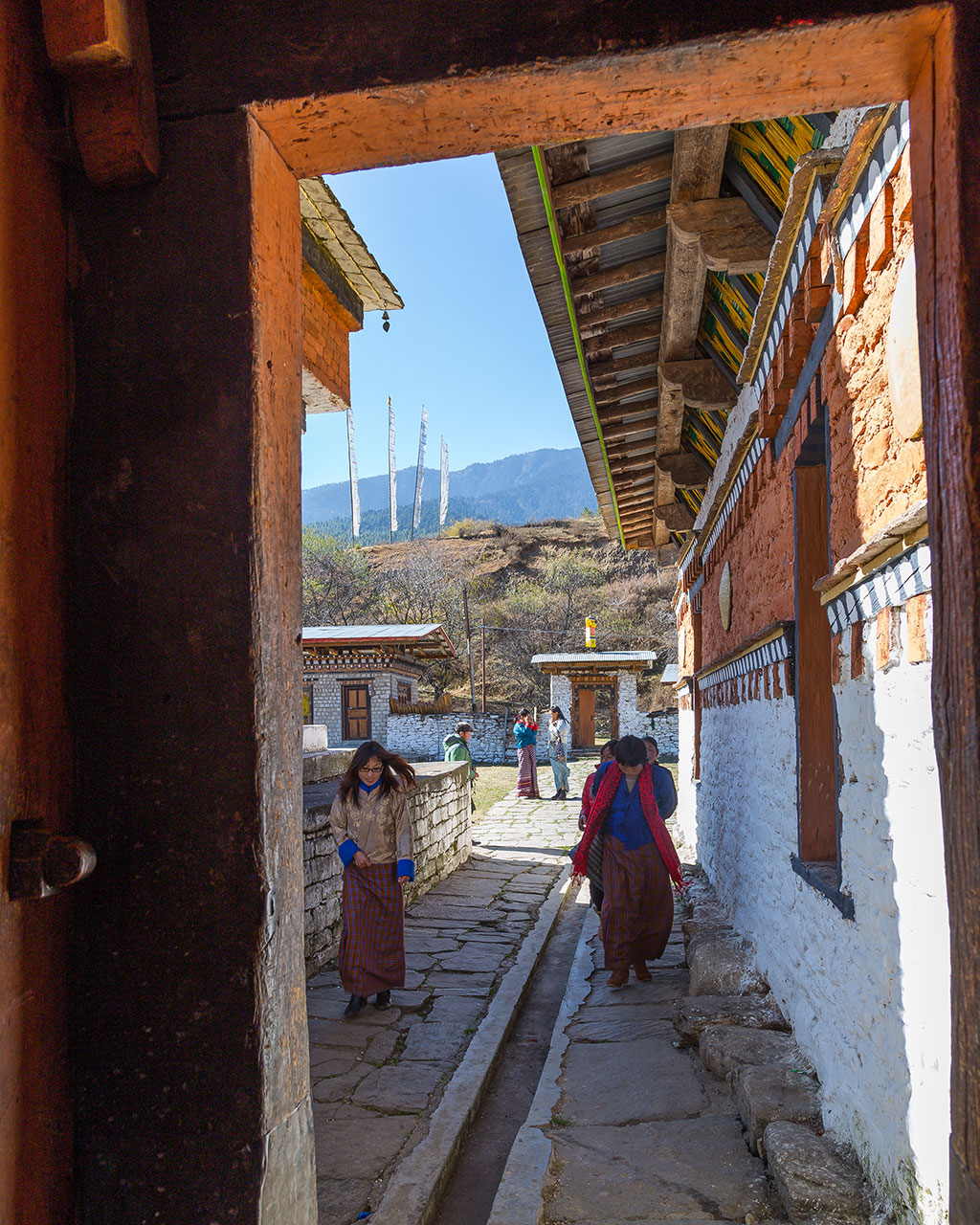 Circumambulating the path around the Jambay Lhakhang, prayer wheels and earthy textures showing the way.